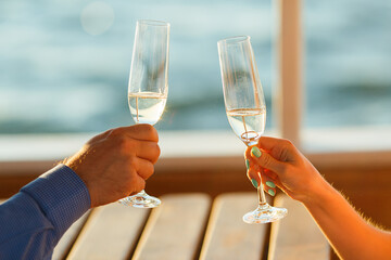 Happy couple drinks champagne on a yacht.