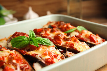 Baked eggplant with tomatoes, cheese and basil in dishware, closeup