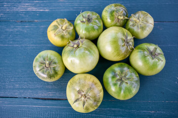 Green tomatoes on the table close up