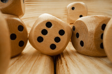 Wooden dice tossed on wooden background close up
