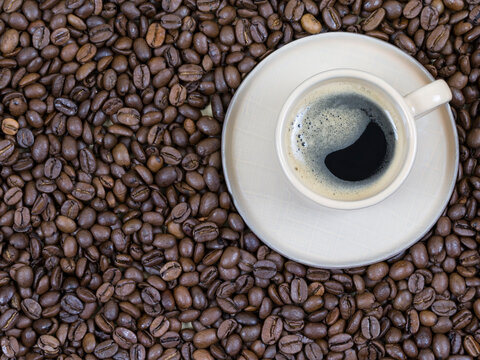 a cup of coffee on the background of coffee beans. View from above © OlgaFet