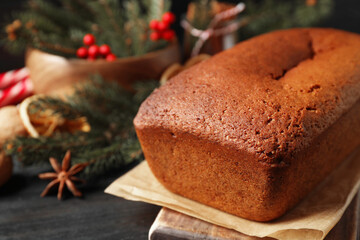 Delicious gingerbread cake and Christmas decor on black wooden table, closeup. Space for text