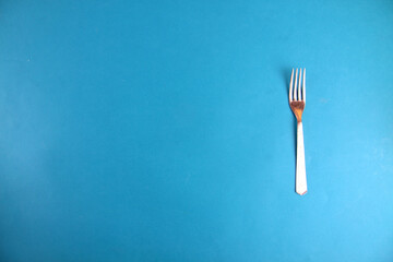 fork isolated on blue background flat lay