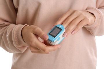 Woman using pulse oximeter for oxygen level testing on white background, closeup
