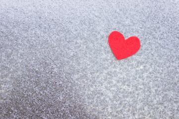 Red felt heart on a frozen window. Red heart on ice. 14 feral, Valentine's Day. Holiday concept, life concept, healthcare, charity, give love