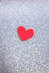 Red felt heart on a frozen window. Red heart on ice. 14 feral, Valentine's Day. Holiday concept, life concept, healthcare, charity, give love
