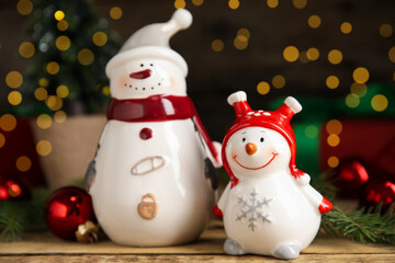 Cute little snowmen and Christmas decor on wooden table