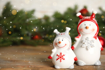 Funny little snowmen on wooden table, space for text