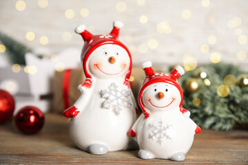 Funny little snowmen on wooden table. Christmas decor