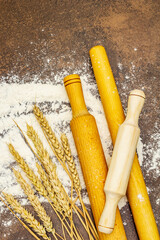 Scattered flour, ears of grain and wooden rolling pins