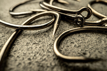Fishing hooks on concrete textured background macro