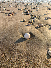 Fototapeta na wymiar Beautiful pebbles on the sand, beach background