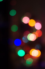 Abstract colored bokeh background of blurred lights garland on black background, for Christmas, New year and holidays