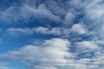 Naklejka na ściany i meble Blue sky background with white spindrift clouds