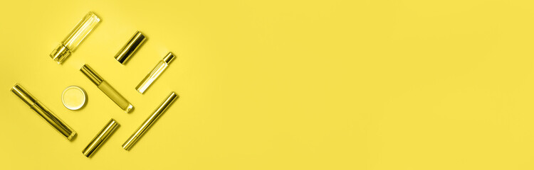 Flat lay composition with decorative makeup products and parfume toned in trendy yellow. Makeup and beaty concept. Color 2021 concept. Web banner.