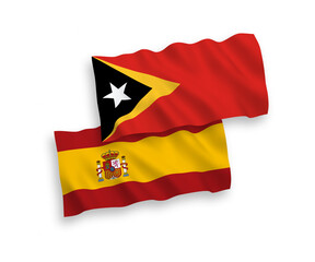 National vector fabric wave flags of East Timor and Spain isolated on white background. 1 to 2 proportion.