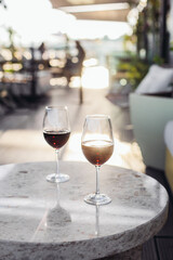 Two glasses of red wine on a rooftop terrace, sunset light 