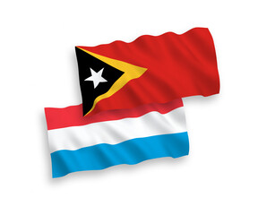National vector fabric wave flags of East Timor and Luxembourg isolated on white background. 1 to 2 proportion.