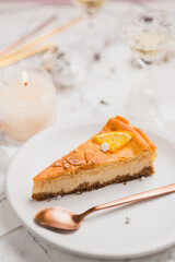 Festive orange cheesecake slice. Serving of traditional Polish cheesecake on Christmas table.