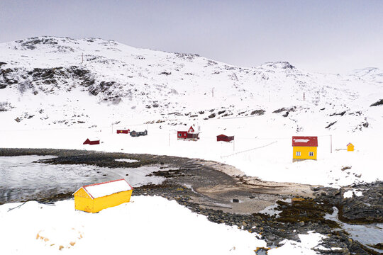 Colorful wood houses in the fishing village of Breivikbotn covered with snow, Soroya Island, Hasvik, Troms og Finnmark, Arctic