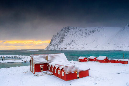 Winter sunset over the Arctic sea and fishermen cabins in the snow, Sorvaer, Soroya Island, Hasvik, Troms og Finnmark