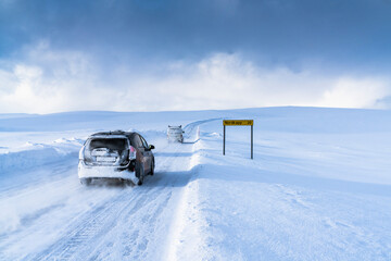 Off road vehicles driving on the icy road towards Nordkapp (North Cape) in the deep snow, Troms og Finnmark