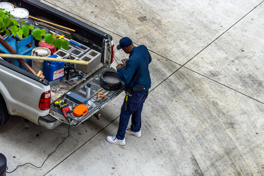 African American Handyman Puts His Tools In Truck.