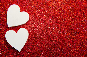 Valentines day concept. White decorative Hearts on red shiny background with copy space. Shiny sparkle metallic glitter texture. Top view, flat lay.