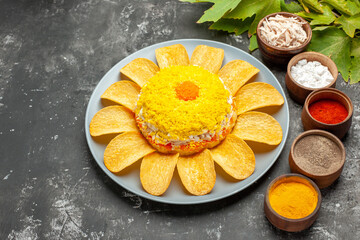 side close view of salad with herbs and leaves on the right side on dark background