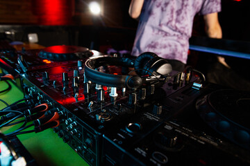 DJ ending working shift. Job in nightclub. Close up photo of disk jockey console or turntables with...