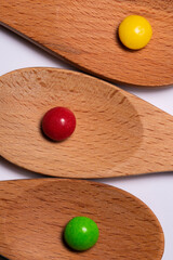 Three Wood Spoons with Candy on White Background