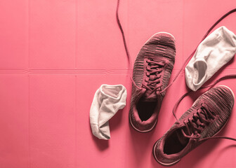 sneaker with socks on the pink fitness rubber mat. sports shoes for indoor training. active...