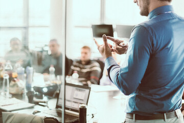 Business man making a presentation at office. Business executive delivering a presentation to his colleagues during meeting or in-house business training, explaining business plans to his employees.