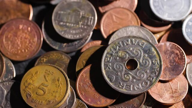 4K Rotating macro close up of old rusty coins from different countries. International currency from Europe, India, Denmark, Japan and many more. Cash collection as travel memory.