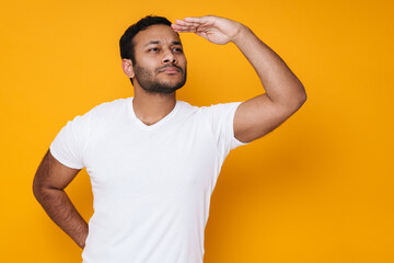 Asian young unshaven man looking aside with hand at forehead
