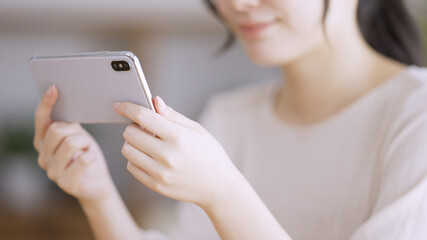 スマートフォンで動画を観る若い女性