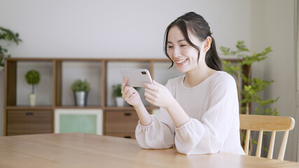 スマートフォンで動画を観る若い女性