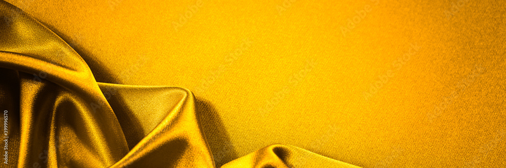 Wall mural yellow orange fabric background. silk satin with soft wavy folds. drapery shiny fabric background wi
