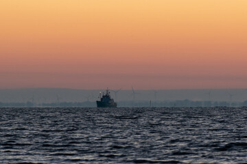 a ship on the sea at sunrise
