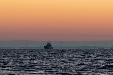 Fototapeta premium a ship on the sea at sunrise