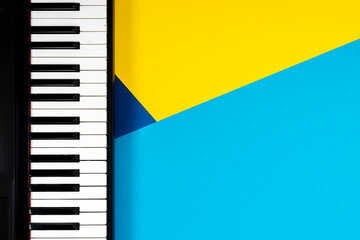 Top view to piano on yellow and blue background. Music learning concept. Top view