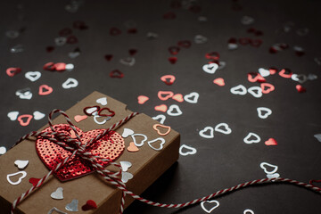 Valentine's day gift box with heart sequins on dark background