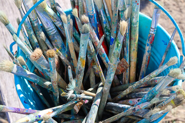 Paint brushes in blue bucket