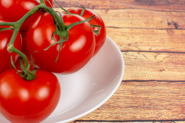 juicy ripe tomatoes on a white plate close up