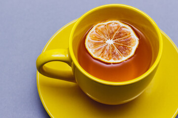 Yellow cup of tea on gray background. Trendy 2021 colors: illuminating yellow and ultimate gray.