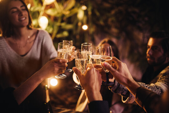 group of people cheering and celebrating with champagne glasses at party together