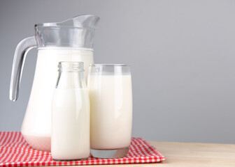  A jug and bottle of milk glass on a wooden table on background.Raw milk is high in calcium and protein to drink for all ages.Milk consumption nutritious and healthy dairy products concept..
