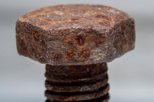 Close-up of a part of an old metal screw covered with rust with fine details clearly visible