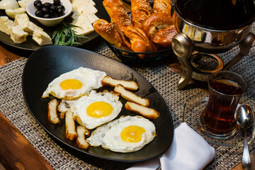 Appetizing scrambled eggs with lard and tea for breakfast in a beautiful form