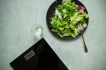 Black scales and salad in a plate on a blue background
